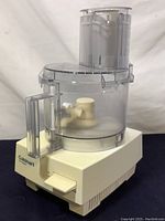 Front and side view of the assembled Cuisinart Pro Classic food processor on a flat surface.