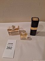 Fragrances lot front view showing all three bottles side by side, Salvatore Ferragamo Signorina with bow cap, Versace small bottle, and Chanel black lipstick style case