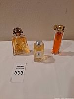 Front view of three designer perfume bottles: Givenchy, Jo Malone London, Nina Ricci