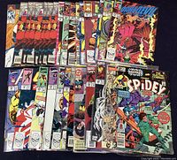 Top laid out view of multiple Marvel comic books mostly overlapping, showing partial covers including Spider-Man, Daredevil, and others