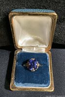 Ring displayed in blue velvet-lined jewelry box