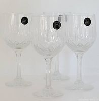Four crystal wine goblets arranged together, showing the clear lead crystal and hand cut pattern.