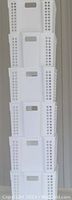 Stack of six new white plastic storage bins showing height and shape