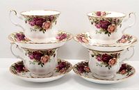 Four Royal Albert Old Country Roses cups and matching saucers arranged for display, showing floral pattern and gold trim on all.