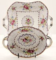 Two Royal Albert Petit Point candy/trinket dishes, one oval and one rectangular with handles, floral cross-stitch design with gold trim.