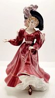 Front view of the Royal Doulton Patricia bone china figurine in a red dress and feathered hat.
