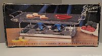 Box showing the vintage Bianca hot stone grill with handles, two burners, and metal rack.