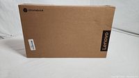 Sealed Lenovo Chromebook box with Lenovo and Chromebook branding on brown cardboard box.