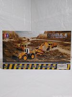 Front of the box showing images of four construction vehicle toys including an excavator, loader, dump truck, and cement mixer under the label Double E Heavy Industry.