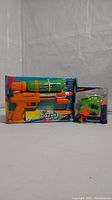 Photo showing Nerf Super Soaker XP30 water gun and Nerf NanoFire motorized blaster in original packaging.