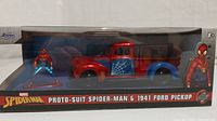 Clear front view of boxed diecast set showing Spider-Man figurine and 1941 Ford pick-up truck with spider web design.