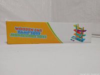 Side view photo of the packaging box featuring text "Wooden Car Ramp Toys Montessori Toys" with ramp toy illustration