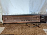 Full view of Lakewood Model 800 radiant heater showing front grill and power cord on brown carpet.