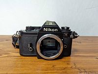 Front view of Nikon EM camera body showing lens mount and textured grip.