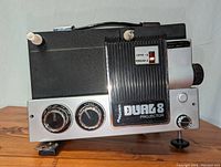 Front view showing dual control dials, lens, and Dual 8 Projector label with Super 8 and Regular 8 selector switch.