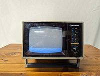 Front view of the Mitsuba vintage portable black and white TV showing the screen and right side control panel with channel dial, slider, and knob.