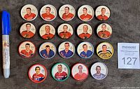 Lot of 19 hockey coins displaying front images with players in team jerseys, arranged in rows, includes various NHL teams.
