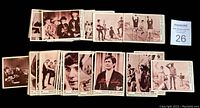 Group of vintage Monkees trading cards laid out, showing black and white images with captions and numbers.