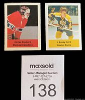 Close-up image showing two individual hockey player stickers featuring Ken Dryden of Montreal Canadiens (#29) and Bobby Orr of Boston Bruins (#4) with names, numbers, and team colors visible.