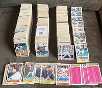Four large stacks of 1979 O-P-C baseball cards on a grey surface with some cards spread around stacks showing players and team checklists.