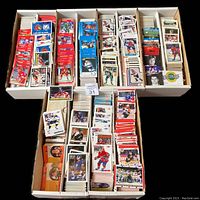 Photo showing an open box with numerous stacks of hockey cards arranged neatly, featuring different players and team uniforms from various series.