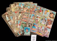 Top view of the layout of multiple vintage baseball cards in protective sleeves, showing a variety of players and teams.