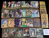 Top-down photo showing a large portion of the baseball insert cards spread in rows, including gold foil cards, reflective cards, and player images mostly in high grade condition.