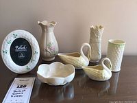 Full view of lot on table including swan figurines, three vases, and photo frame