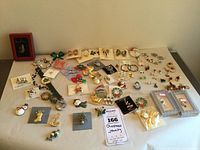 Overview of assortment of Christmas themed costume jewelry items laid out on a flat surface including pins, earrings, and brooches.