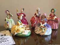 Group view of all six Royal Doulton young lady porcelain figurines arranged on polished surface