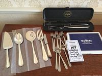 Overview of the serving set including the cake/pie server, large spoon, slotted spoon, serving fork, butter knife, small forks, and the boxed carving set.
