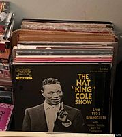Photo showing vinyl records with the front record being The Nat King Cole Show live 1957 broadcasts album.