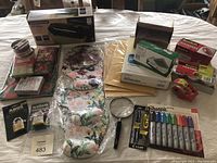 Wide view of all office supplies including paper shredder box, gift boxes, padlocks, mouse pads, magnifying glass, envelopes, pens, and tape.