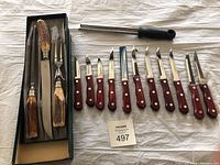 Full set overview including Henckels carving set in original box, Tramontina steak and kitchen knives, and black-handled grater.