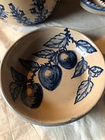 Interior of small bowl showing hand-painted blue fruit and leaves