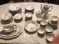 Wide view of the entire Hertel-Jacob Bavarian porcelain dining set arranged on table showing various plate sizes, bowls, serving dishes, and coffee set pieces.