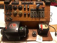 Front view of custom wood control panel featuring Lionel Type ZW transformer with dual control knobs and multiple genuine Lionel switches, bells, and accessory controllers mounted on the panel.