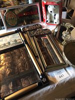 Lot display showing multiple decorative mirrors, Coca-Cola polar bear collectible, Ballantine mirror sign, and gold-tone trays with perfume bottle and rose tray