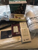 All items arranged on a bed showing the heated throw blanket box, nursery organizer, pillowcases, and duvet insert in packaging.