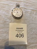 Photo of the front face of the vintage Waltham pocket watch showing the watch dial, hands, and crown.