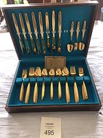 Full view of the vintage gold vermeil flatware set for eight in a fitted case.