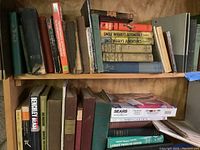 Books displayed on wooden shelves showing a variety of vintage titles, some related to gardening, children, and adventure stories.