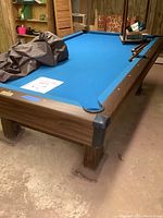 Brunswick Richmond Model GY pool table with blue felt and wood grain frame, pocket detail shown.