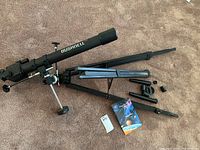 Full view of Bushnell 565 telescope laid out with tripod stand, eyepieces, and instruction manual on carpet