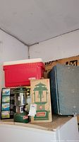Group shot showing Coleman lantern, Thermos cooler, Styrofoam cooler, and boxes