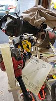 Photo showing Craftsman Speed Start weedwacker trimmer with manual attached, alongside other equipment.