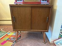 Front view of cabinet showing two sliding doors and tapered legs