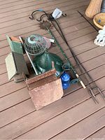 Overview of all items laid out on porch floor including feeders, shepherd hooks, birdhouse, and accessories
