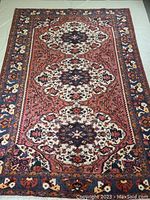 Full view of the hand-knotted Persian wool rug with visible triple medallion pattern and decorative borders in blue and red tones.