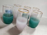 Set of six mid-century modern Blendo drinking glasses in blue-green and frosted glass with gold rims, arranged together.